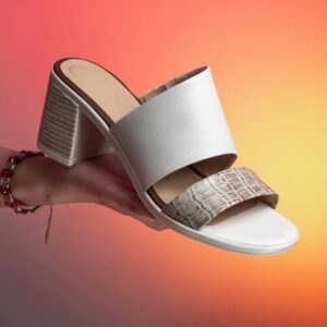 White and Snakeskin Mule held in Hand